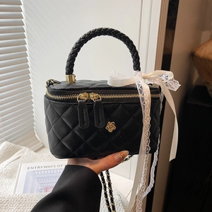 Elegant black quilted crossbody bag with gold floral accents and white lace bow