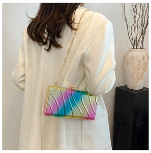 Détail de la pochette arc-en-ciel avec texture ondulée et bandoulière en chaîne dorée