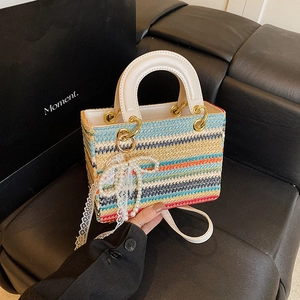 Sac à main tissé coloré à rayures avec poignées blanches et breloque noeud doux