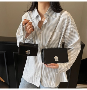 Comparison of two sizes of black leather chain bags with silver lock on model