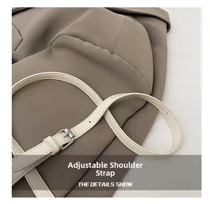 Macro detail of adjustable off-white faux leather shoulder strap with silver buckle
