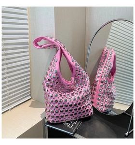 Detail of hot pink hobo bag with silver round studs reflecting in a side mirror