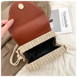 Detailed interior of woven straw crossbody bag showing magnetic snap and lining