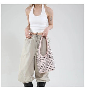 Pink underarm bag with silver rivets shown on a model wearing casual summer outfit