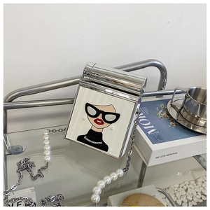 Detail of silver frame handbag featuring a stylish cartoon print and pearl chain strap