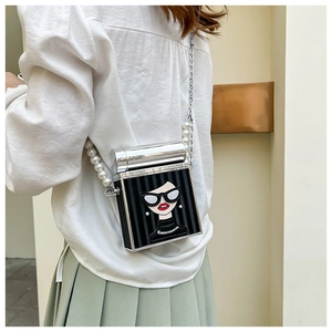 Detail of cartoon girl print on mini black crossbody bag with pearl chain strap