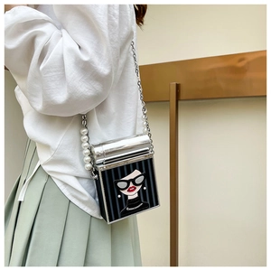 Detail of cartoon illustration on a mini square crossbody bag with pearl chain strap