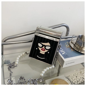 Detailed shot of velvet mini bag with pearl chain and fashion girl embroidery