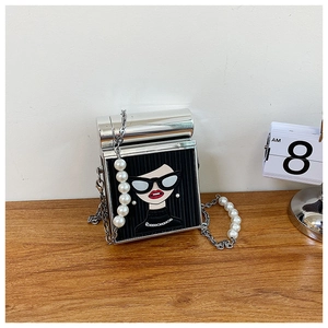 Detail of trendy box bag with fashion portrait, silver frame and pearl chain strap