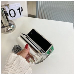 Detail of silver metallic mini bag featuring interior makeup mirror and faux pearl accents