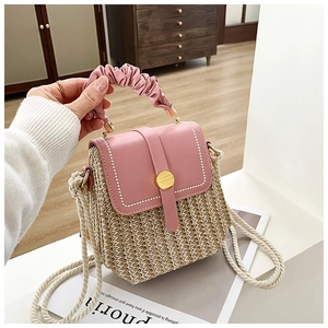 Detailed close-up of pink PU leather flap and woven straw texture with a magnetic gold buckle