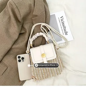 Dettaglio della piccola borsa intrecciata con patta in pelle rispetto alla taglia iPhone 12