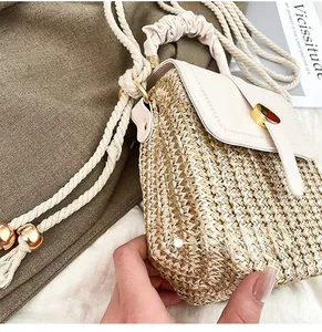Dettaglio della borsa in paglia con patta in pelle bianca e fibbia cilindrica in metallo dorato