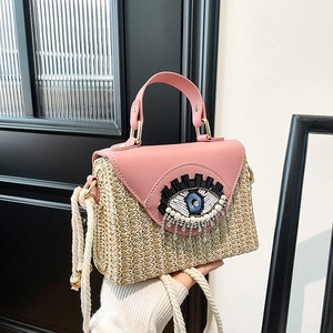 Handmade woven straw handbag with pink leather trim and sequined eye detail decoration