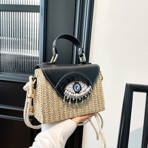 Handmade woven shoulder bag with leather evil eye flap and decorative pearl tassels