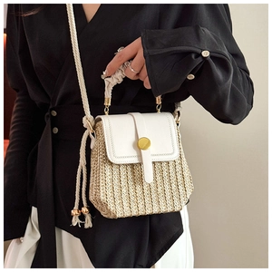 Dettaglio borsa in paglia intrecciata e pelle bianca con fibbia magnetica dorata