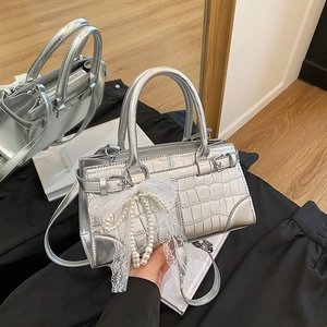 Silver croc-effect handbag with lace bow and pearl charm for a trendy look