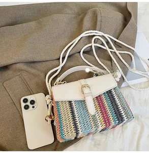 Detail of colorful woven straw bag with cream leather accents and braided rope strap