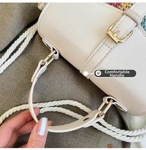 Close-up of woven cotton rope handle and gold buckle detail on straw shoulder bag