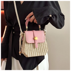 Dettaglio borsa a tracolla in ecopelle rosa e paglia intrecciata con fibbia dorata e corda