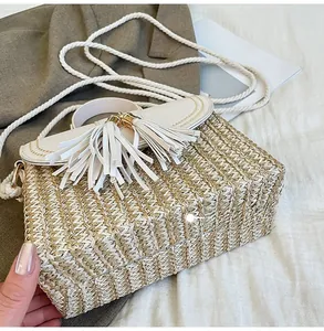 Detailed bottom view of straw woven crossbody bag with white leather fringe and rope strap