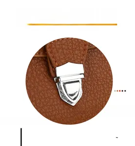 Close-up of exquisite shield-shaped silver hardware on brown pebble grain leather bag