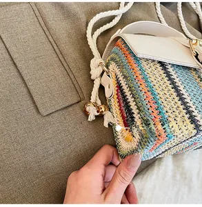 Close-up of multicolor woven straw bag with thick rope strap and gold metal accents