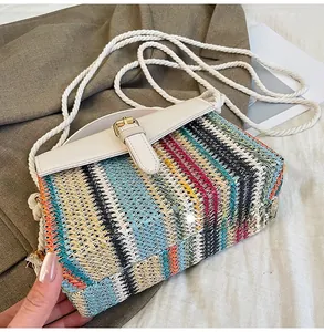 Detailed bottom view of colorful striped woven straw beach bag with white leather flap