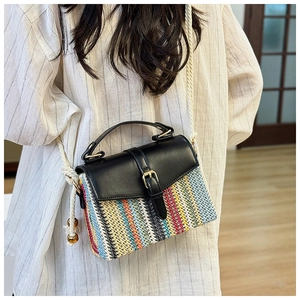 Detail of colorful woven straw mini crossbody bag with black leather flap and white rope strap