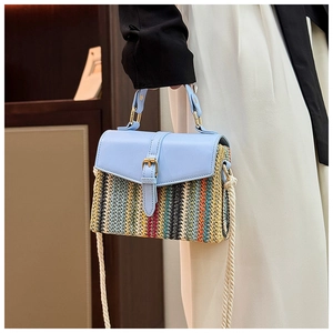 Detail of multi-color woven straw bag featuring blue PU leather flap and rope shoulder strap