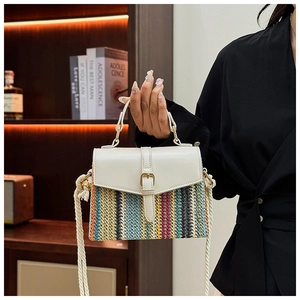Detail of colorful striped woven straw bag with white leather flap and gold buckle