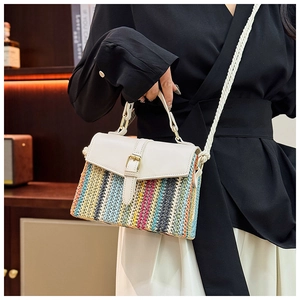 Detail of colorful striped straw bag with white leather flap and thick rope shoulder strap