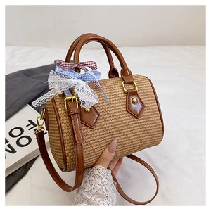 Détail d'un sac cylindrique tissé avec dentelle et rubans colorés à nœuds papillon