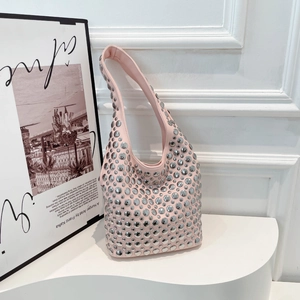 Pink hobo shoulder bag with silver rivet details displayed on a modern white stand