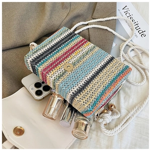 Detailed view of bohemian striped straw bag interior showing storage space for phone
