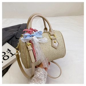 Détail du sac Boston en paille tressée avec nœud à carreaux bleu rouge et ruban dentelle
