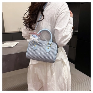 Sac Boston tissé bleu avec nœud rouge présenté sur un modèle en mode lifestyle