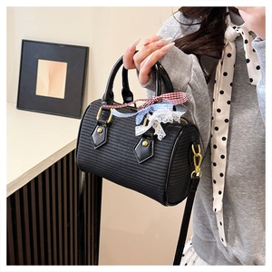 Détail de la texture tressée et du nœud sur le sac Boston noir à bandoulière