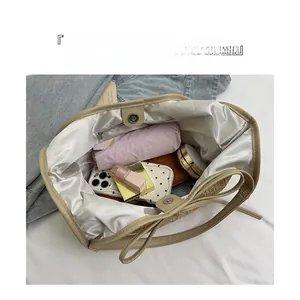 Vue intérieure montrant la grande capacité et les compartiments de ce sac fourre-tout en paille
