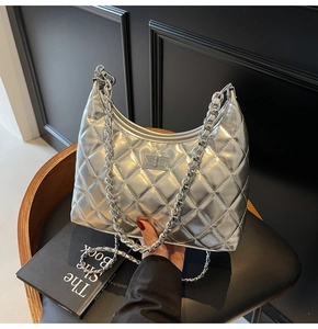Detail of silver quilted hobo bag with chunky chain strap and metallic twist lock