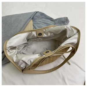 Internal view of straw tote bag showing satin lining and magnetic closure detail