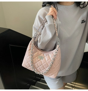 Detail of pink patent leather hobo bag with quilted pattern and silver metal twist lock