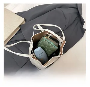 Top view showing the spacious interior of the white bucket bag with daily essentials