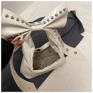 Detail of off-white bow handbag featuring silver studs and magnetic metal closure