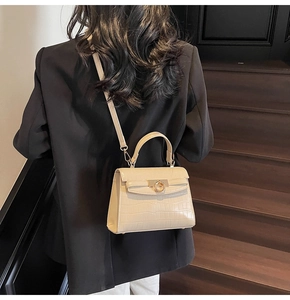 Model view showing the cream crocodile pattern shoulder bag on a vintage staircase