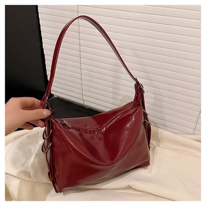 Detail of burgundy patent leather tote showing shiny texture and silver ring hardware