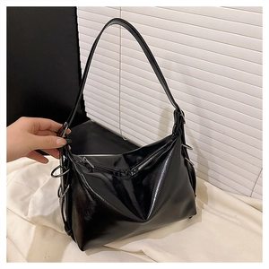 Detail of glossy patent leather tote bag with silver metal rings and smooth surface