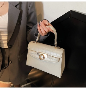 Macro view of beige crocodile embossed leather with a luxury golden round metal lock