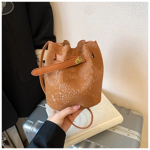 Detailed view of brown python-embossed leather bucket bag with gold twist lock