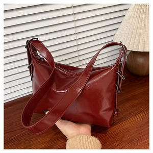 Detail of burgundy glossy faux leather tote bag with adjustable wide shoulder strap